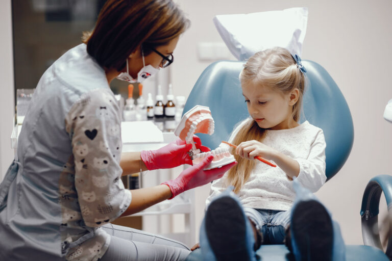 cute little girl sitting in the dentist s office